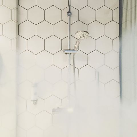 The easiest way to rid your shower tiles of grout is regular upkeep, which is why our cleaning expert Heloise says you should run a squeegee over tile after every use. By drying the walls, you'll prevent mildew stains.